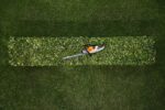 El hsa 30 de Stihl descansando en el seto que acaba de perfilar