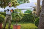 UNA PERSONA CORTANDO UN SETO CON EL HSA 40 DE STIHL. -SE FELIZ CORTANDO SIN RUIDOS LOS SETOS. DETU JARDIN